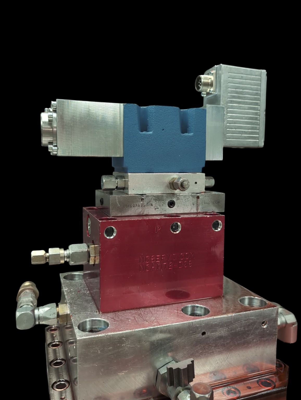 A technician interfacing with a modern servo valve with digital controls at an NC Servo Technology testing station.